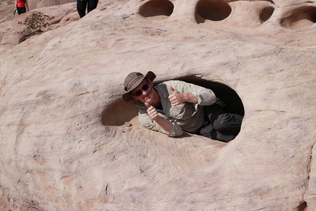 man peeking out of hole