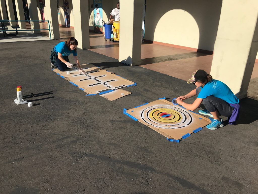 people spray painting shapes
