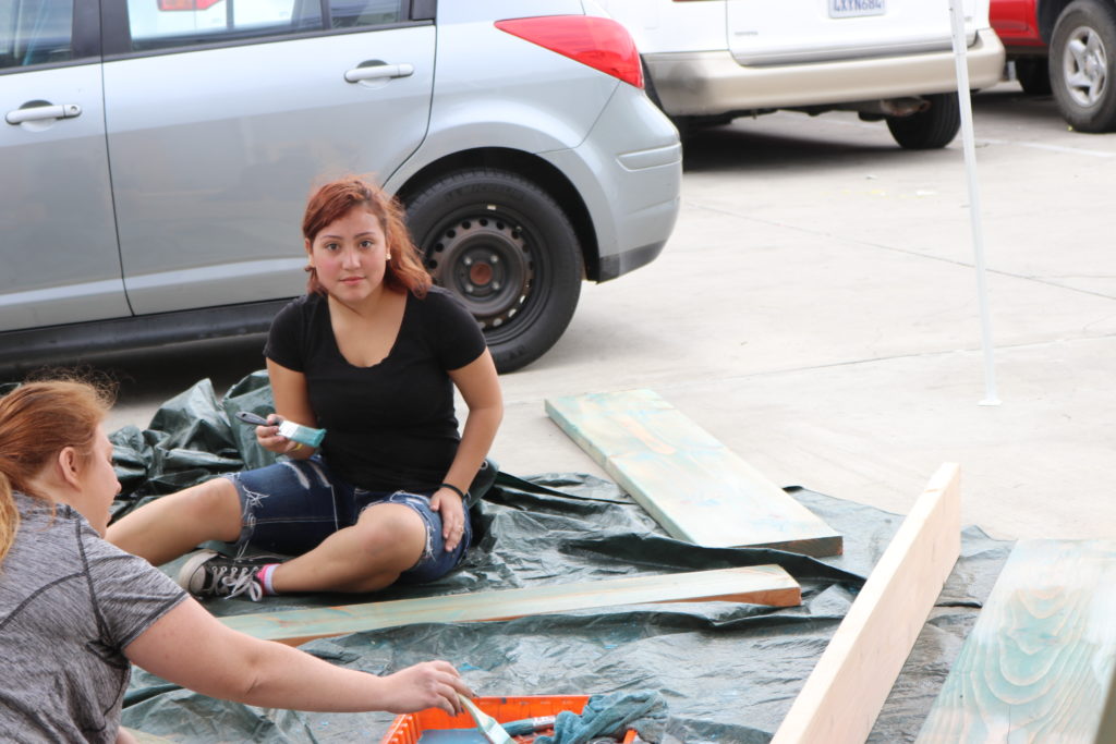 woman looking up from painting boards