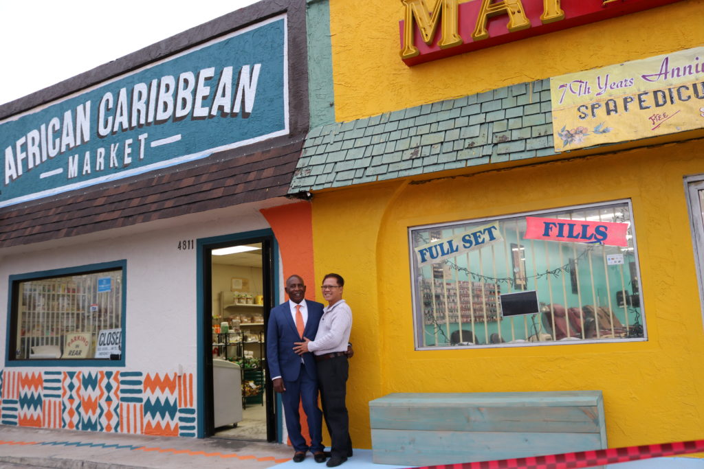 owners pose outside market