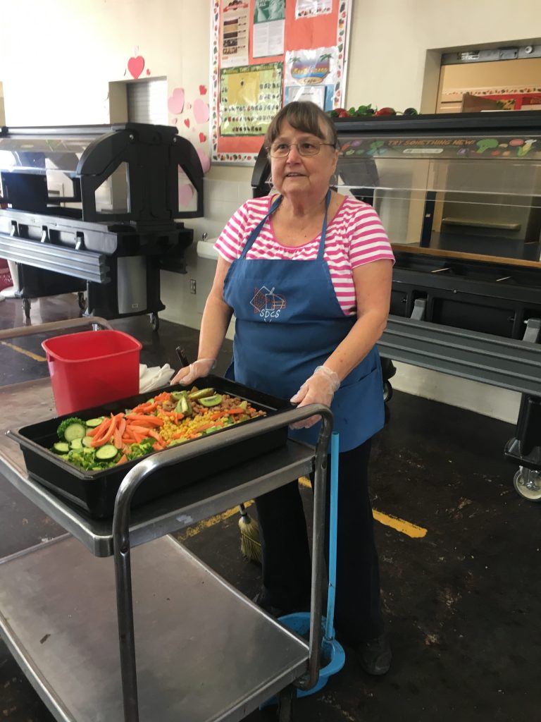 woman with salad greens in basket