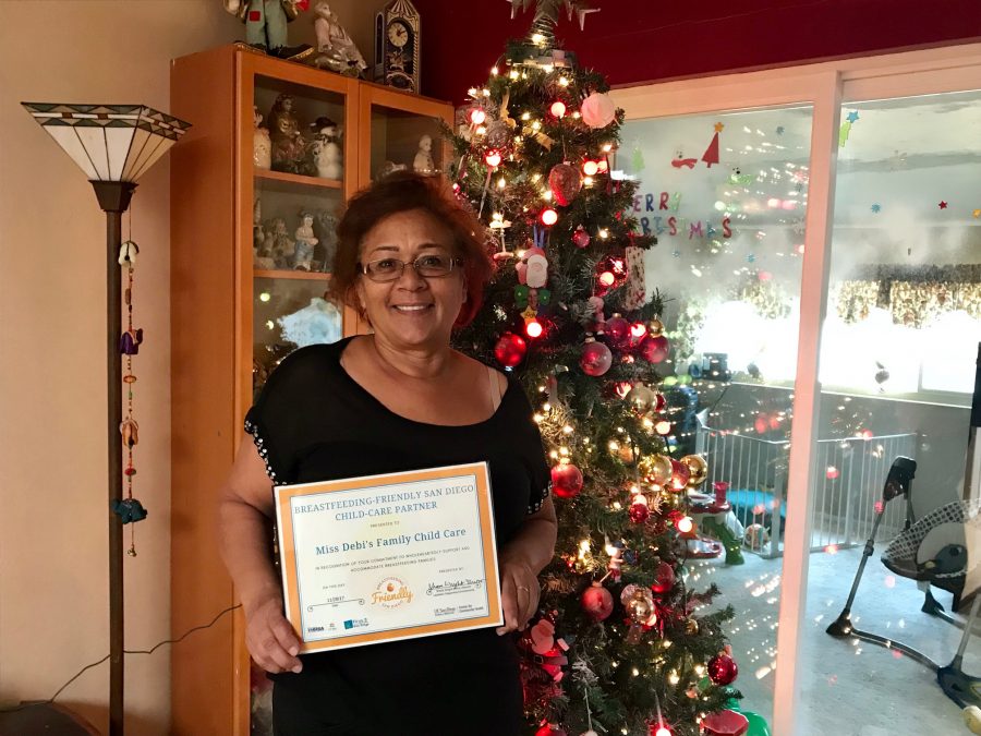 Debi Rowland smiling with certificate